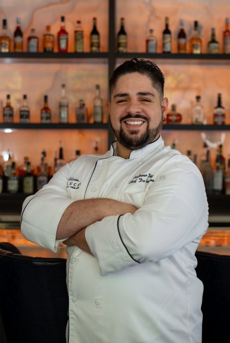 chef Andrew Diaz in his chef coat in front of the Austin downtown bar