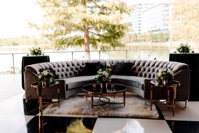 Woodlands terrace with gray couch overlooking the waterway