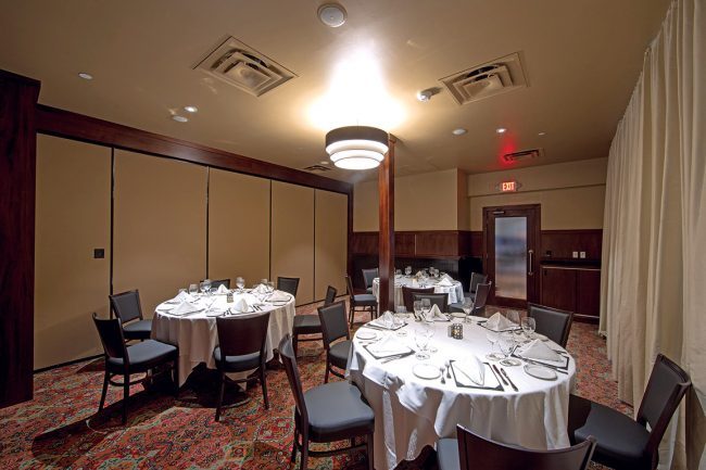 Truluck's Arboretum Atlantic Room view from the NE corner looking toward the entry door, 3 round tables with place settings