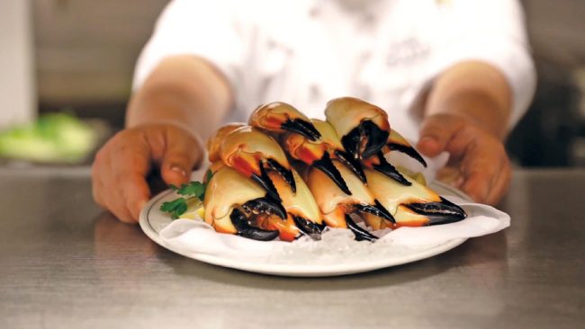 picture of Florida Stone Crab claws on a plate, being served by a Truluck's chef