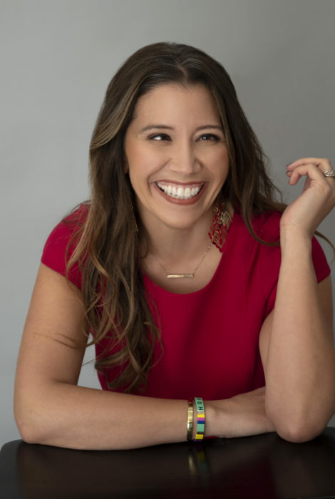 picture of event coordinator Amber Scheer in a red dress, smiling