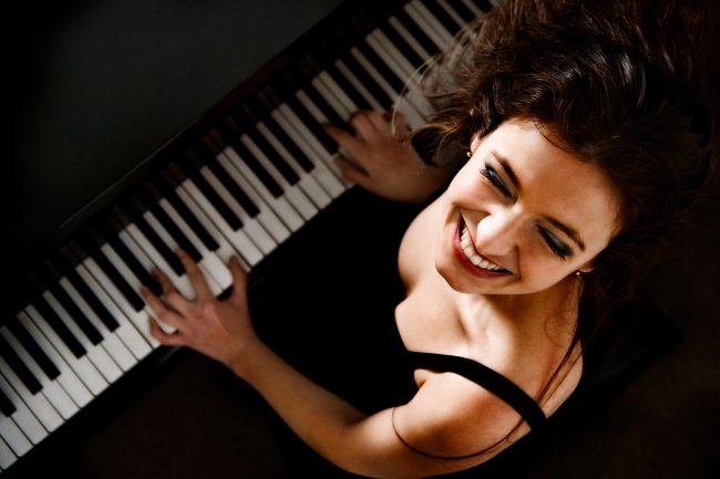 picture of a piano entertainer smiling and playing the piano