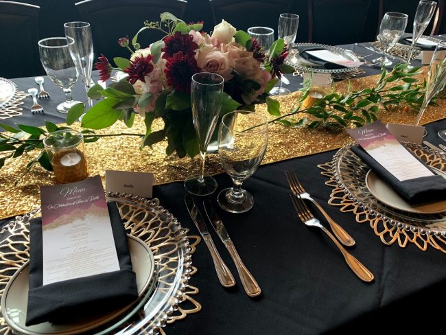 picture of Truluck's Woodlands private dining event with gold accents, deep purple Dahlias and dusty rose pink roses.