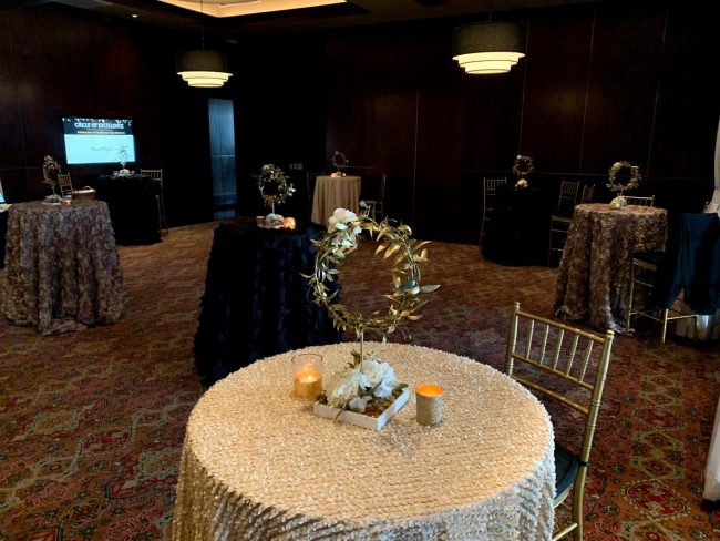 picture of Truluck's Woodlands private dining reception style event with gold and navy accents and a unique centerpiece that looks like a crown of gold leaves.
