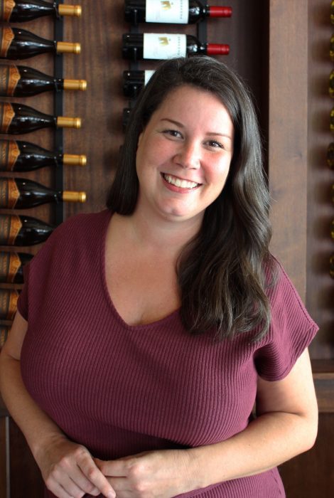 Monica Leibowitz sales manager in front of the wine wall in Dallas