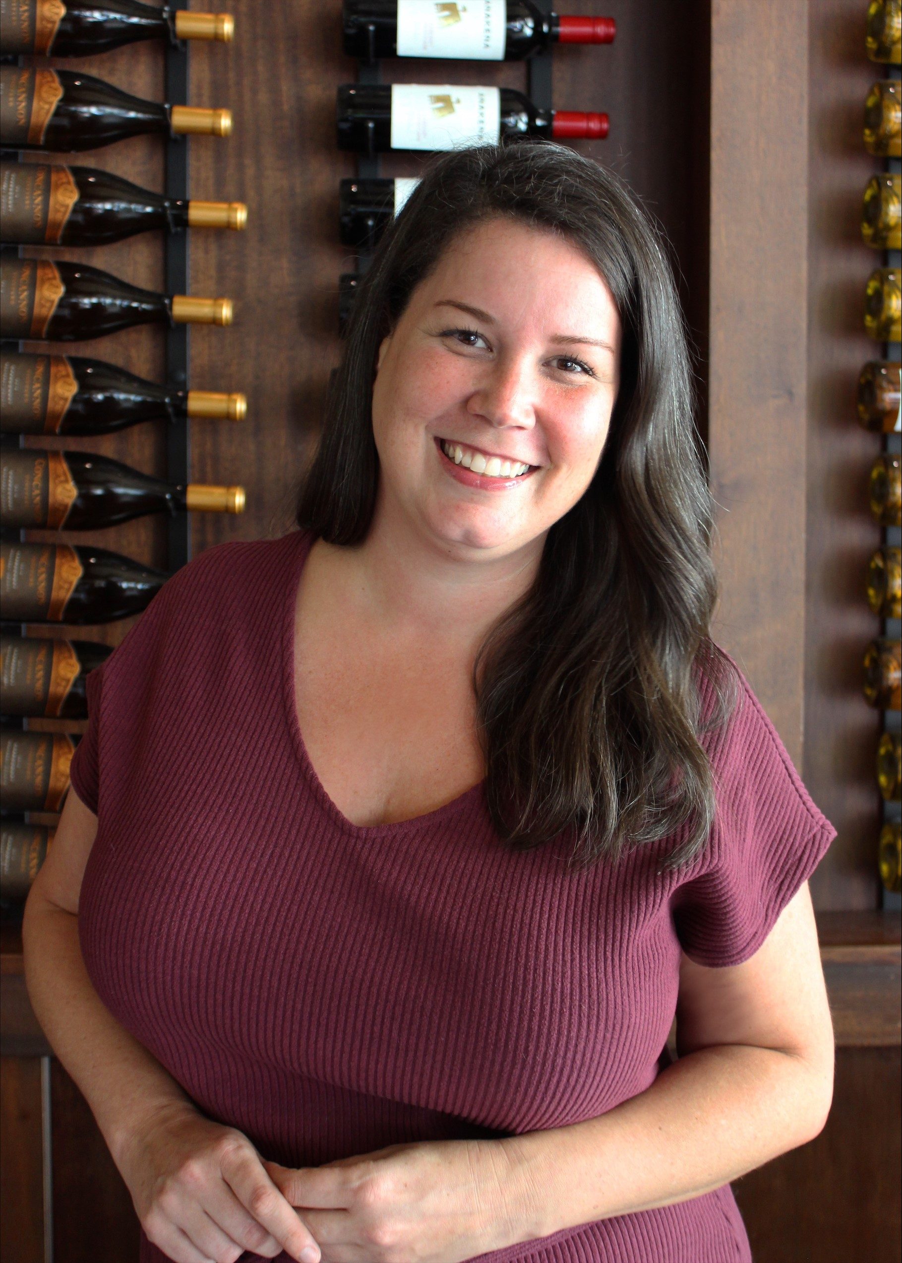 Monica Leibowitz sales manager in front of the wine wall in Dallas