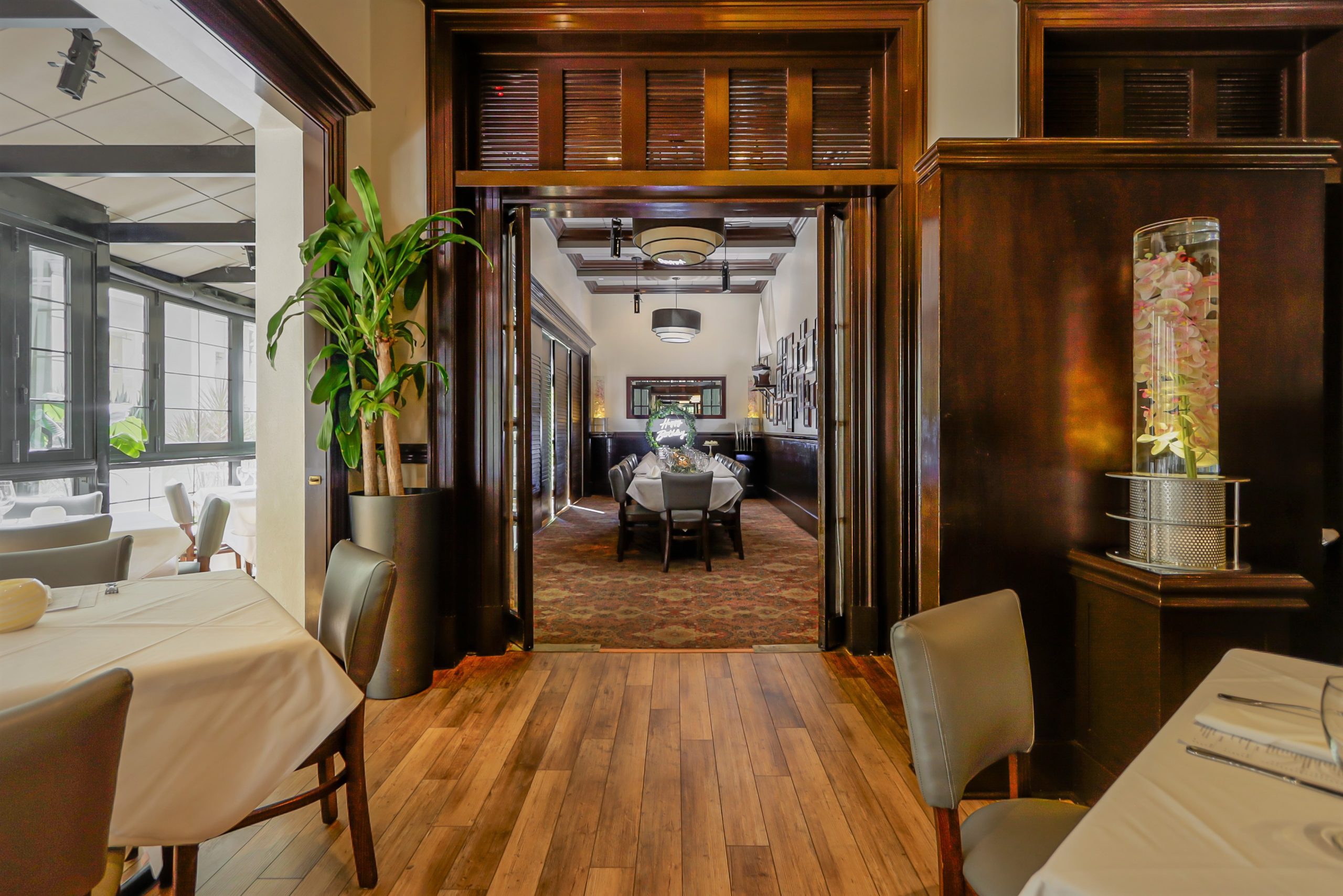 View of the Naples room in Naples, FL from the entry door into the room with a long table setup