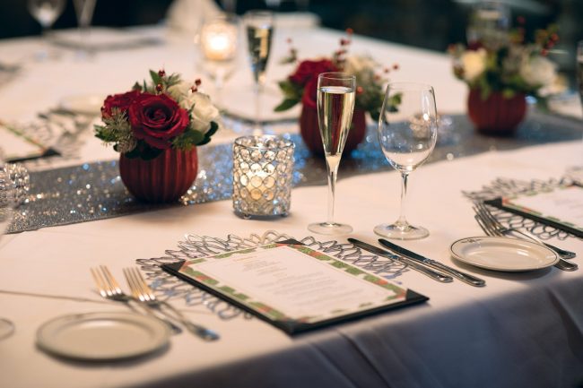 picture of private dining holiday floral centerpiece with red and white roses and holiday greenery