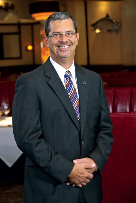 Picture of Managing Partner, Mike McClure in the dining room in a suit and tie