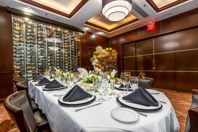 the Brickell Room in Miami decorated in black and gold with a balloon backdrop
