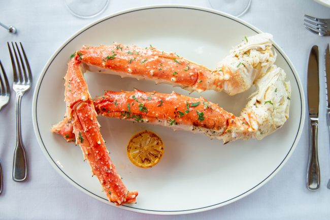 picture of Alaskan prime king crab legs on a plate with a lemon wheel
