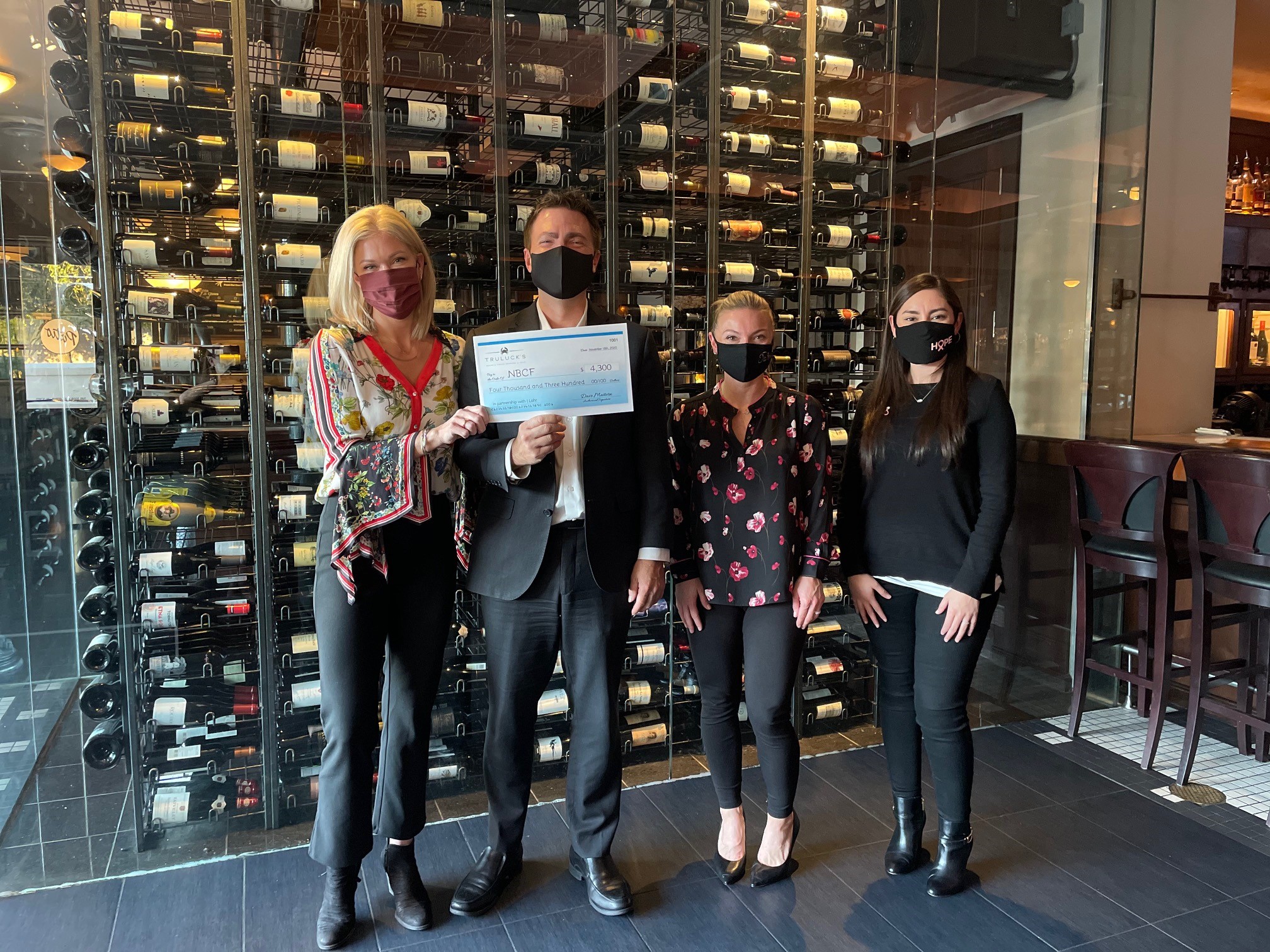 picture of Truluck's team handing off the donation check to National Breast Cancer Foundation in partnership with J. Lohr Carol's Vineyard