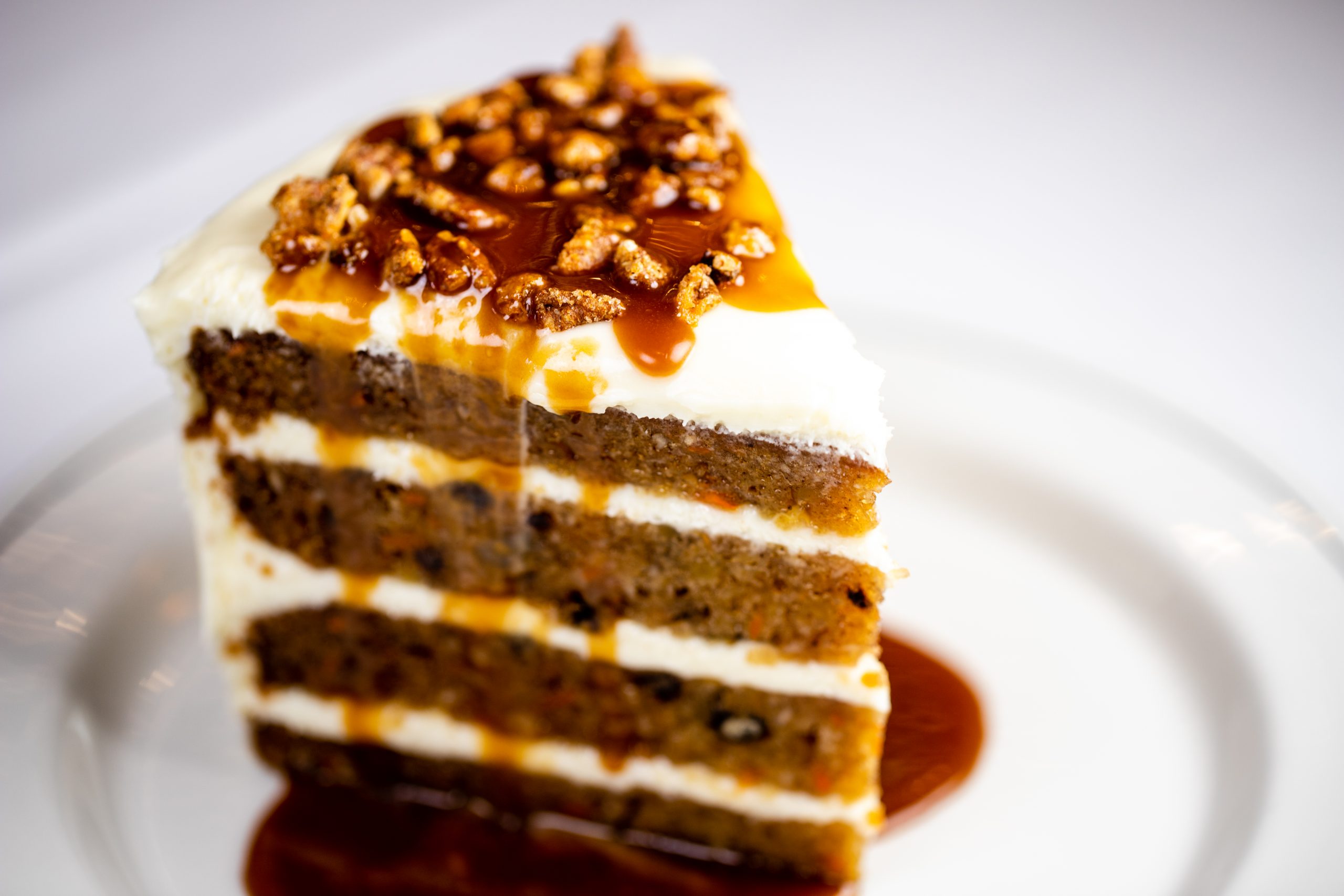 picture of Carrot Cake drizzled with butterscotch sauce and topped with spiced pecans