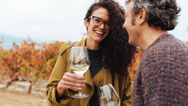 picture of a man and woman smiling and holding Rioja wine glasses