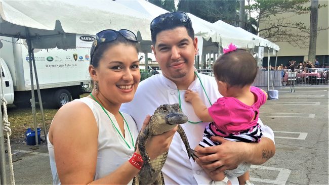 Chef Michael Cerny with his wife and daughter holding a baby alligator