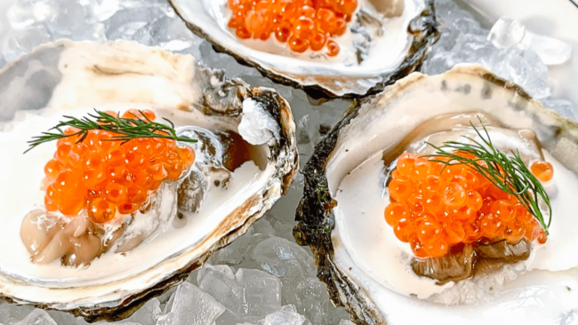 picture of Belon oysters topped with creme fraiche, Ora King caviar and fresh dill on a bed of ice