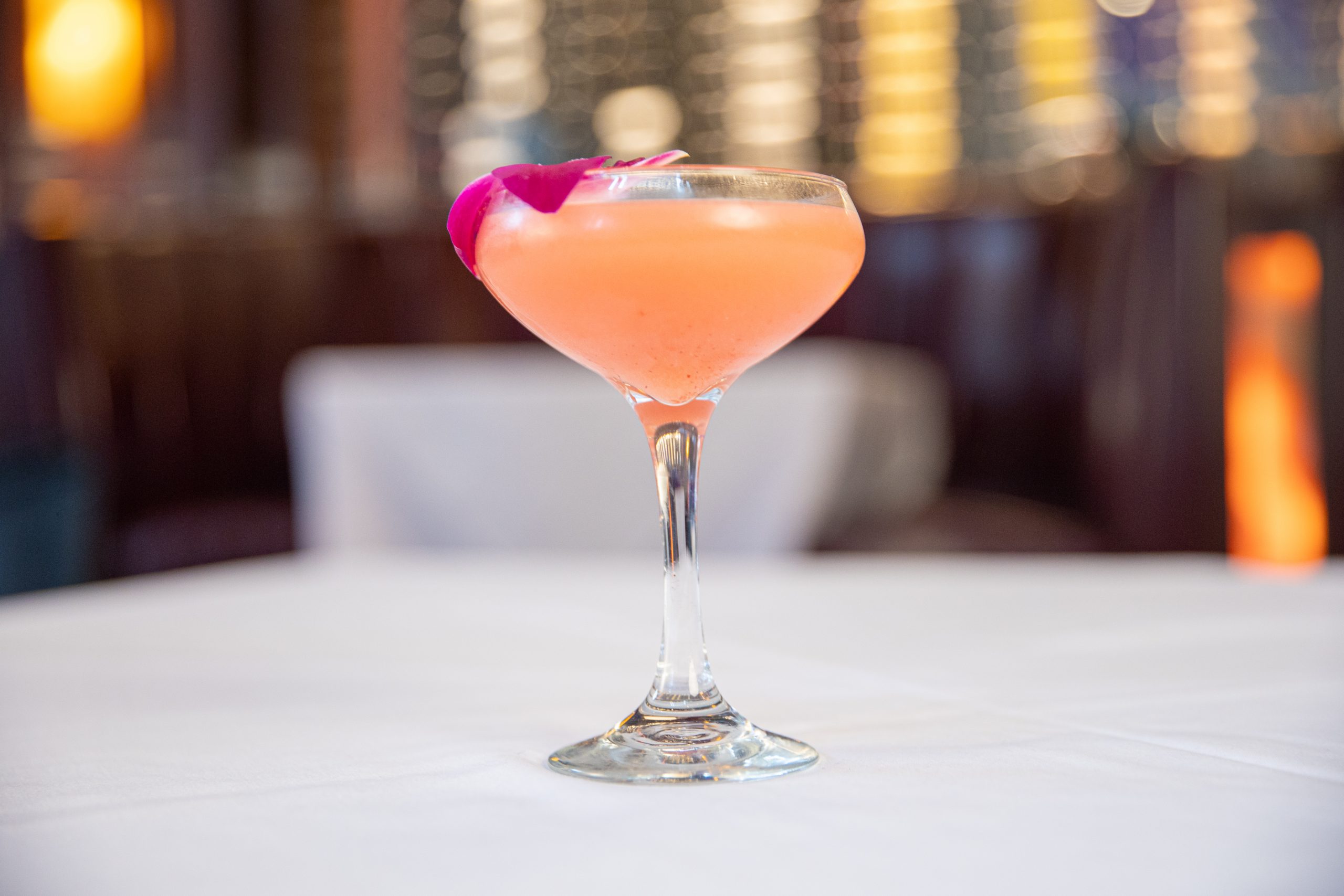 picture of the pretty in pink cocktail with an orchid garnish