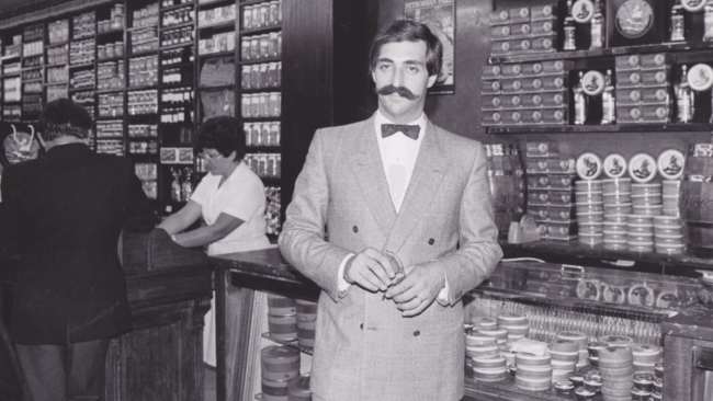 picture of one of the Petrossian brothers in his store dressed in a suit with a bowtie