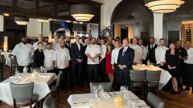 picture of the Truluck's Naples staff smiling in the dining room all gathered for a group photo