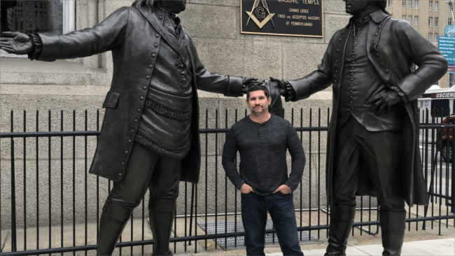 picture of Chef Odel between two large historical statues