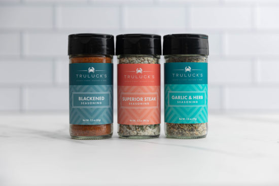 picture of Truluck's seasonings garlic and herb, superior steak seasoning, blackened seasoning on a kitchen counterop