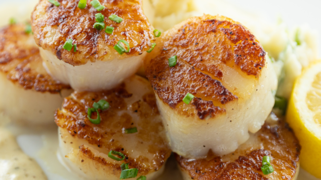 overhead picture of Truluck's scallops with popcorn picatta sauce and topped with fresh chives