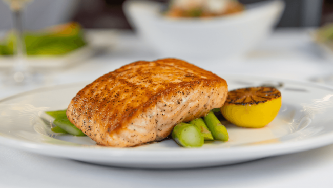 pan seared salmon filet over asparagus with a grilled lemon