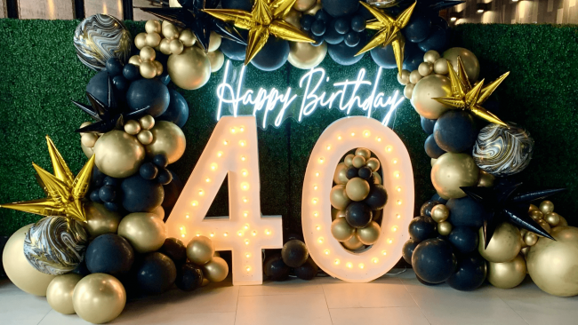 photo of a balloon backdrop with a happy birthday neon sign and large light up numbers 4-0