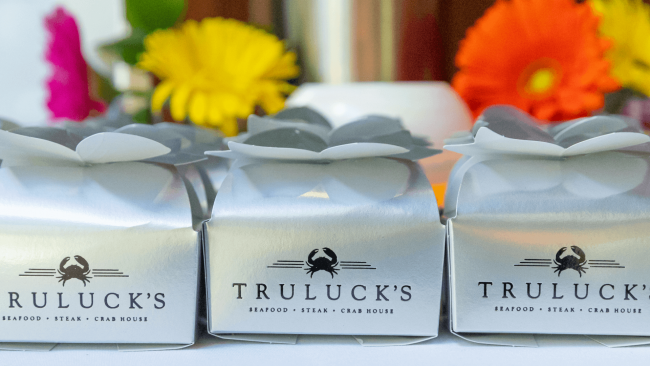 photo of Truluck's Seafood, Steak and Crab House silver truffle boxes with Gerber daisies in the background