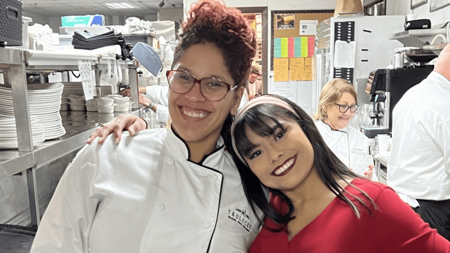 Truluck's cocktail server and server smiling and posing in the kitchen