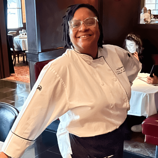 Truluck's server in the dining room posing while smiling