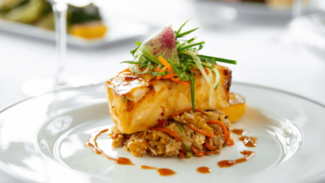 miso seabass fish on top of crab fried rice with cucumber slaw and a watermelon radish