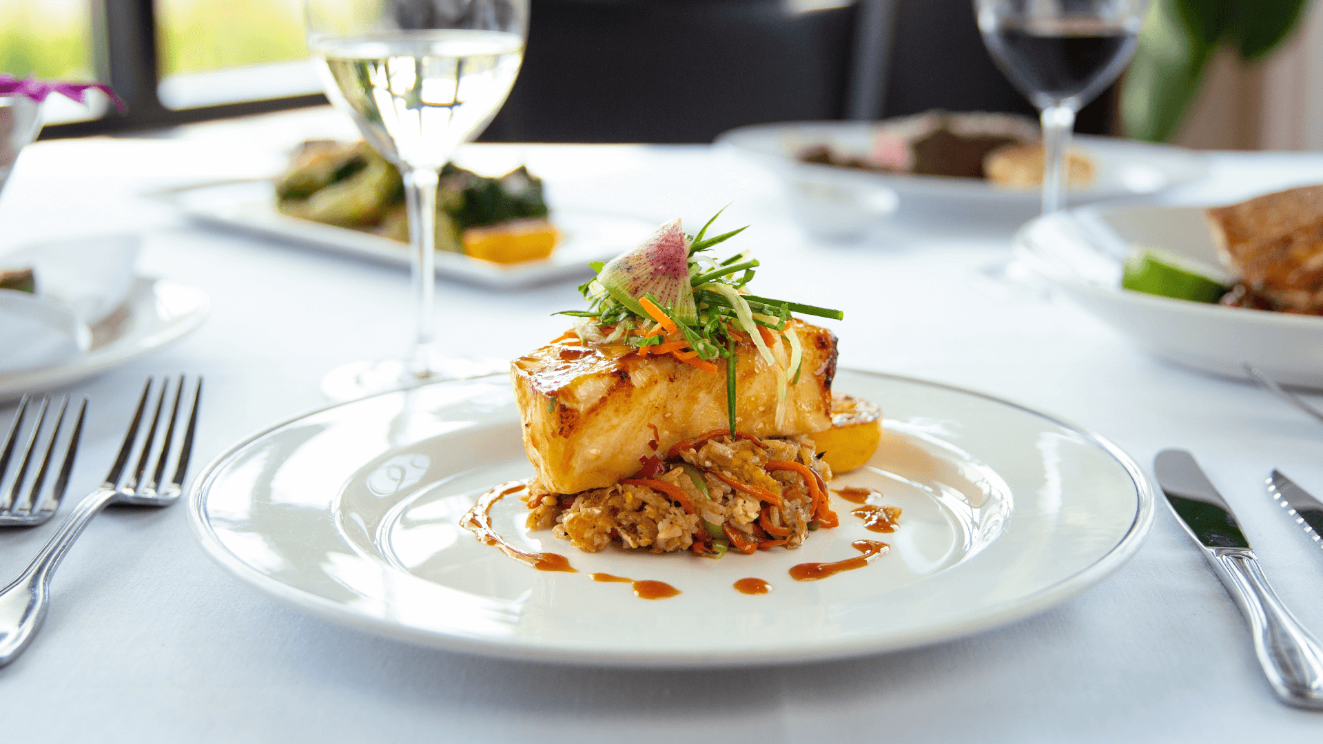miso seabass fish on top of crab fried rice with cucumber slaw and watermelon radish