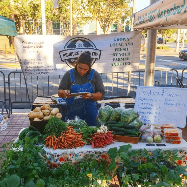 Chef Andrew at a farmers market selling lots of fresh vegetables