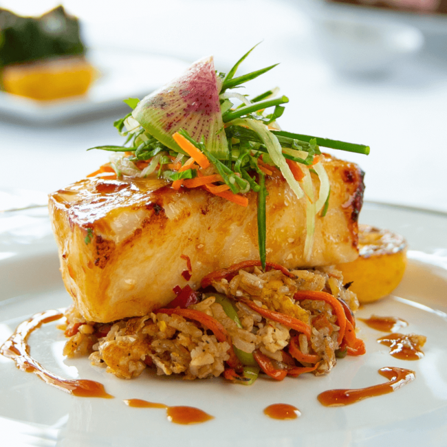 miso glazed seabass on top of crab fried rice topped with cucumber slaw and a watermelon radish