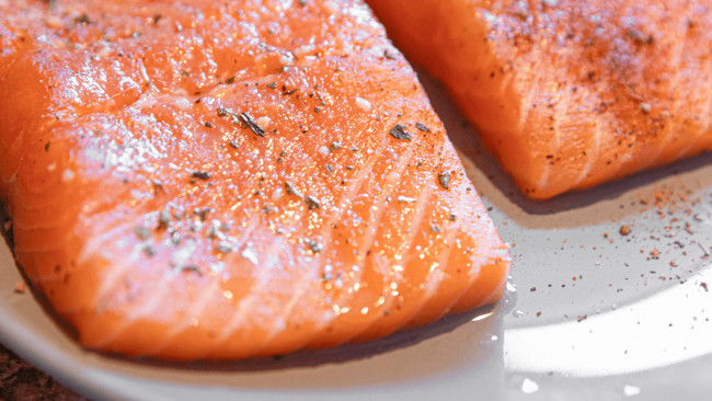 photo of raw salmon filets topped with garlic and herb seasoning