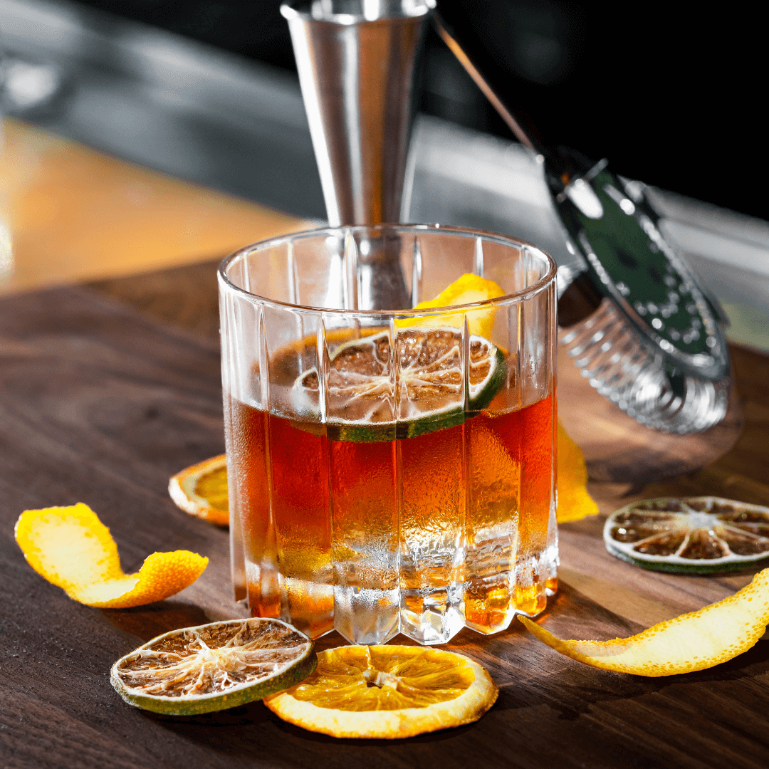 picture of the Rum Fashioned cocktail surrounded by dried citrus wheels in a ridged rocks glass