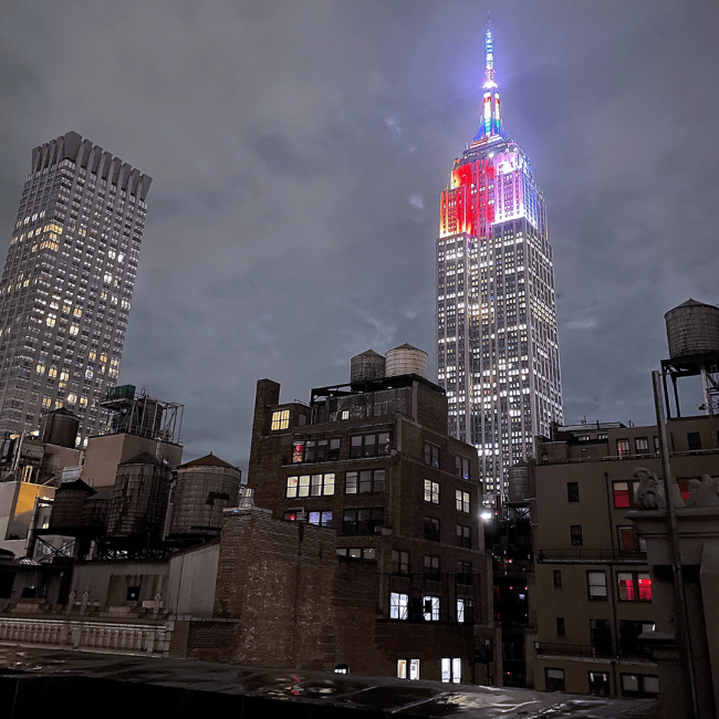 The Empire State Building in New York City lit up in red, white and blue