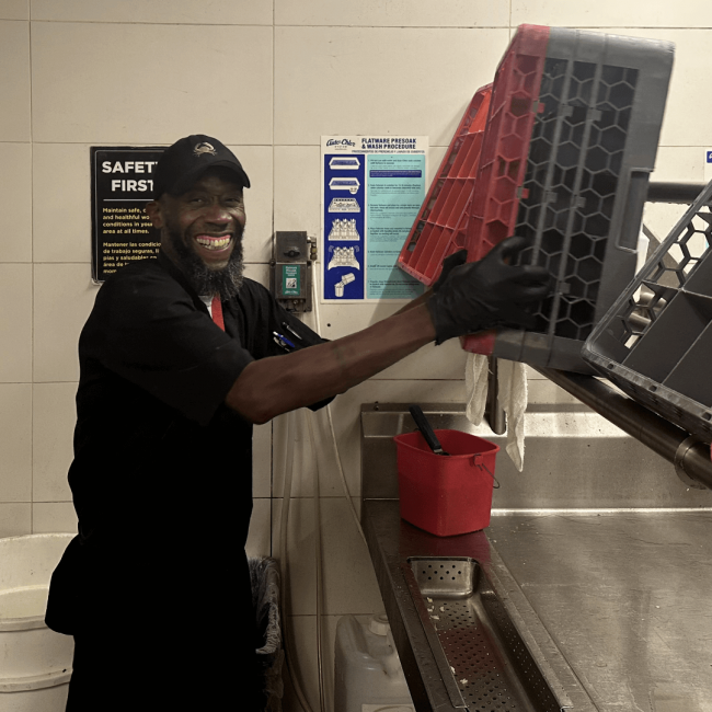 photo of The Woodlands dishwasher, Andre setting up a glass rack in the dish pit