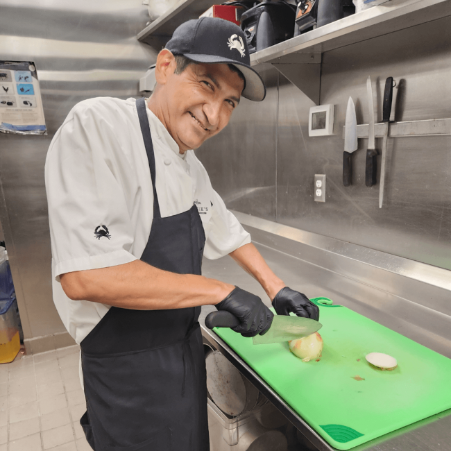 photo of Ledde chopping onions in the kitchen and smiling