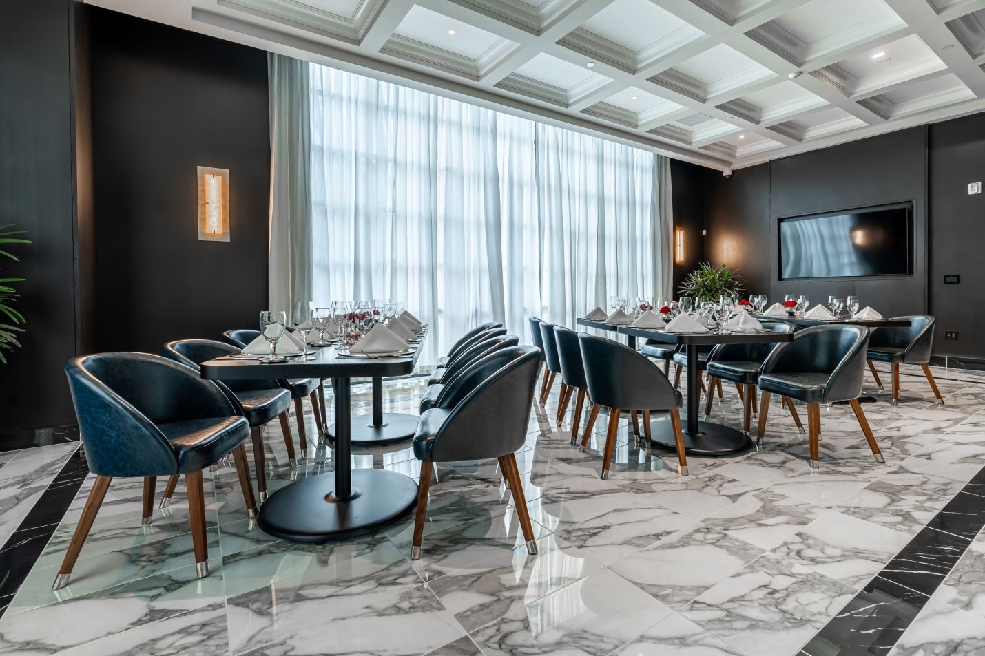 The Trident private dining room in Plano with peacock blue chairs, marble flooring and white drapery covering the windows