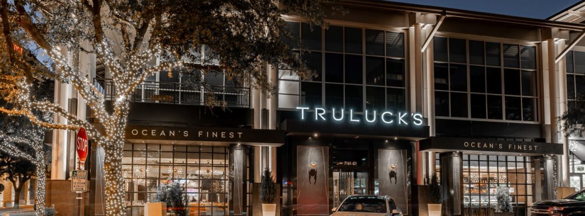 exterior of Truluck's Plano at twilight with a white Mercedes parked out front