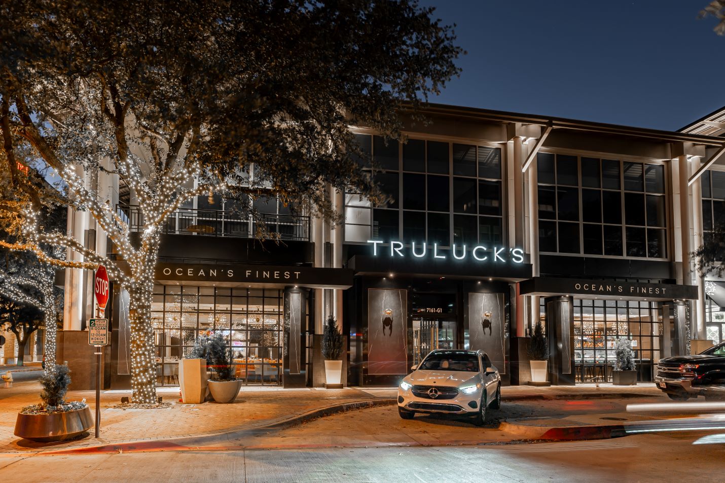 exterior of Truluck's Plano at twilight with a white Mercedes parked out front