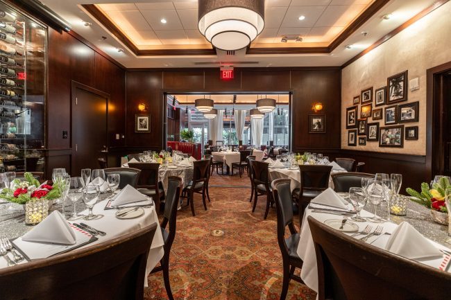 VIEW OF THE NAPLES ROOM LOOKING OUT INTO THE MAIN DINING SPACE. TABLES SETUP WITH ROUND TABLES