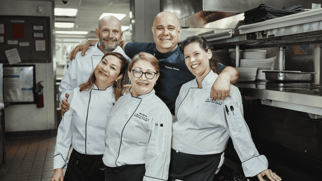 Chef Thomas with a few servers in uniform at the Houston location