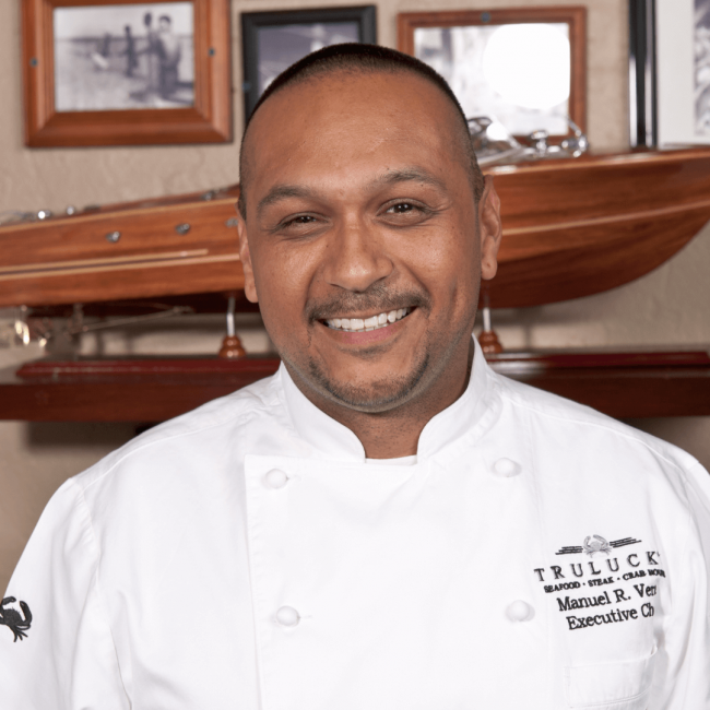 Chef Manny's in his chef coat in the private dining room