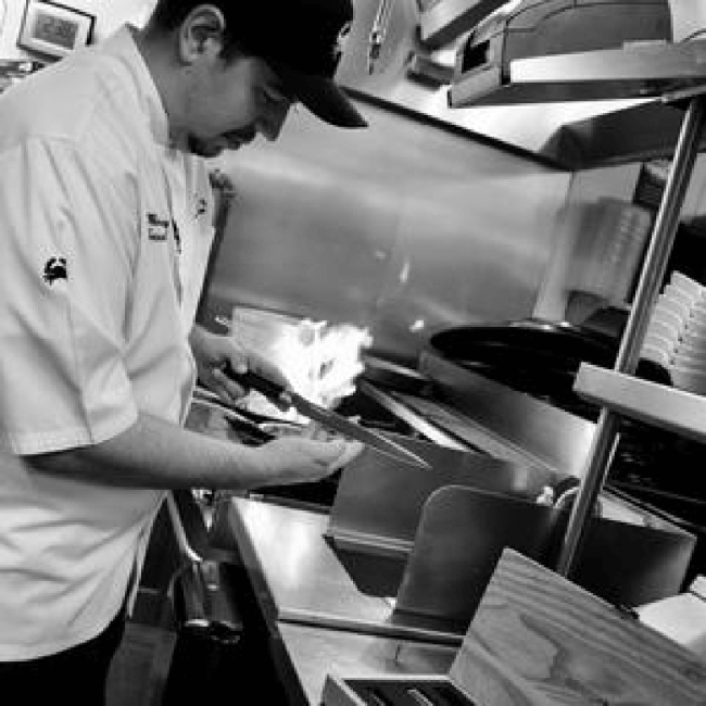 chef Cerny checking the sharpness of his knife on the kitchen line