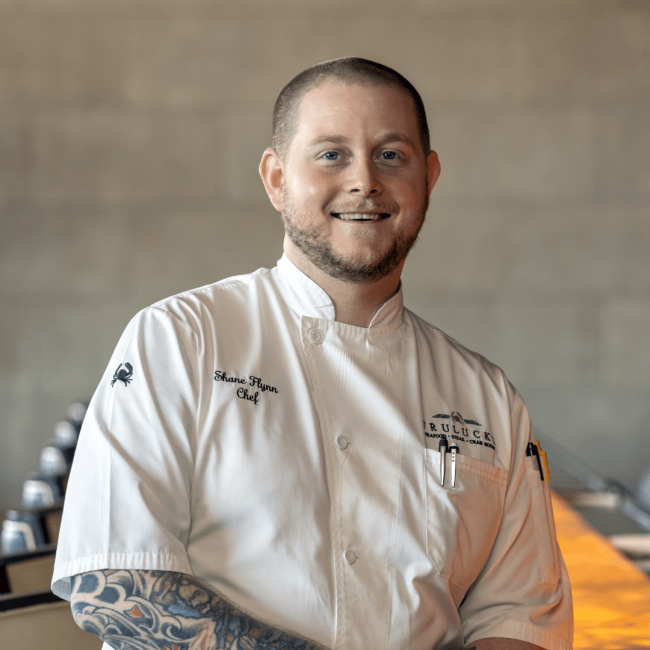 Chef Shane in his chef coat in front of the bar