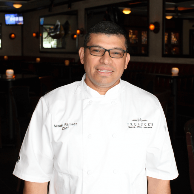 chef Misael Ramirez in his chef coat in the dining room
