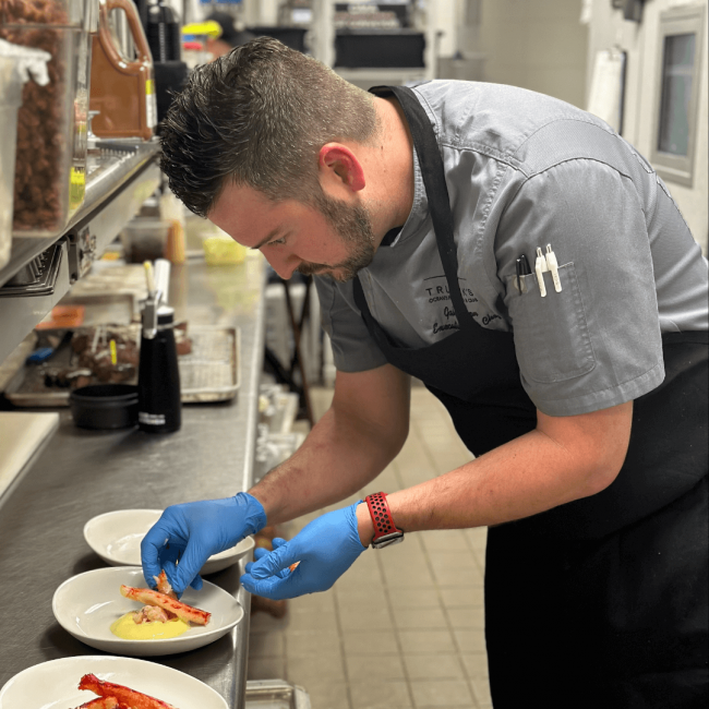 chef Gabe in the kitchen putting together a dish of king crab for a wine dinner